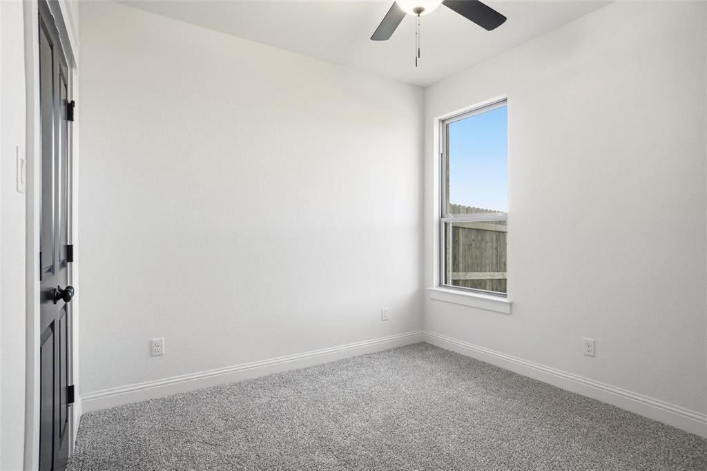 218 Legacy Boulevard Weatherford, TX 76086 - Photo 14 of 20 an empty room with a chandelier fan and windows