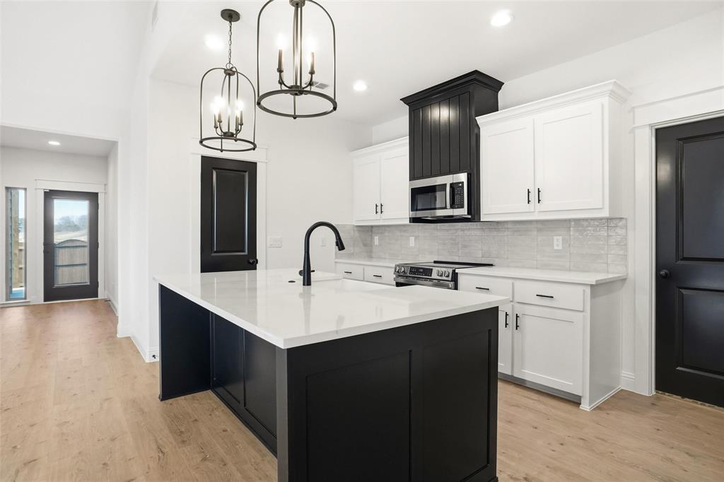 218 Legacy Boulevard Weatherford, TX 76086 - Photo 4 of 20 a kitchen with stainless steel appliances a sink and cabinets