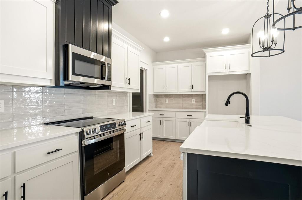 218 Legacy Boulevard Weatherford, TX 76086 - Photo 5 of 20 a kitchen with cabinets stainless steel appliances and wooden floor