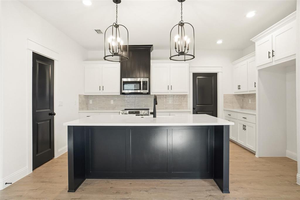 218 Legacy Boulevard Weatherford, TX 76086 - Photo 8 of 20 a very nice looking kitchen with granite countertop a sink cabinets and stainless steel appliances