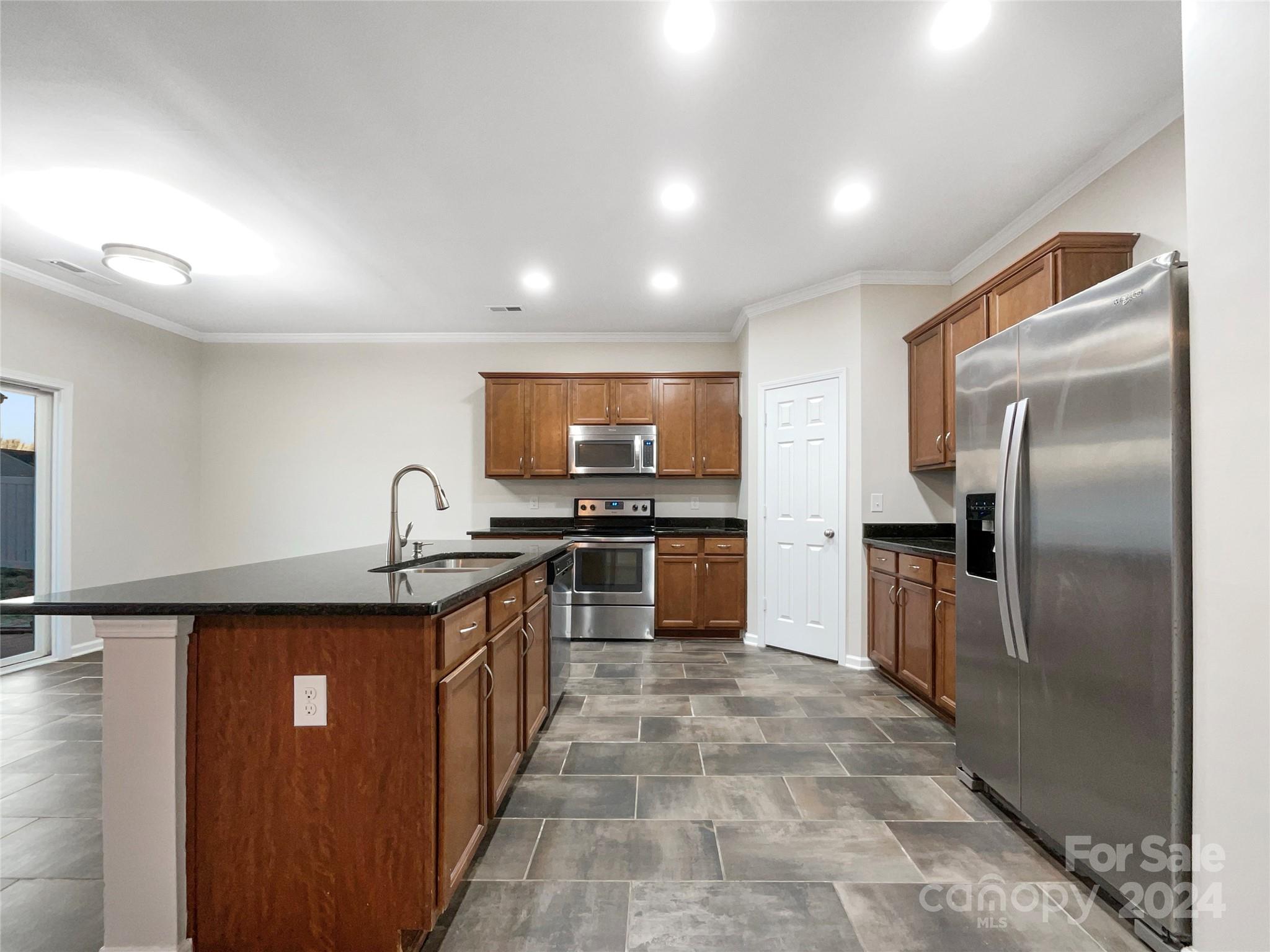 1005 Garden Web Road Indian Trail, NC 28079 - Photo 13 of 25 a kitchen with stainless steel appliances granite countertop a sink a stove and refrigerator