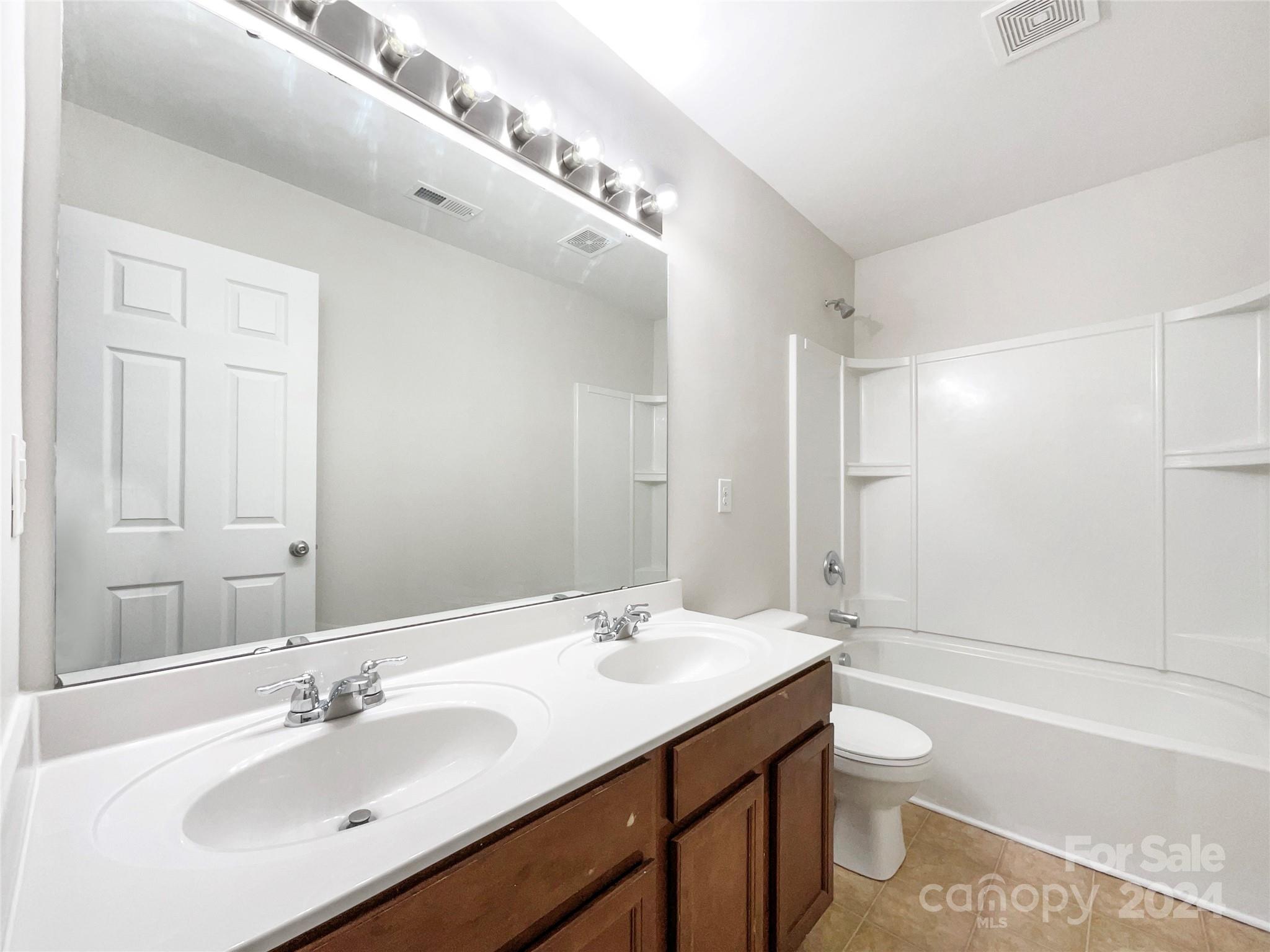 1005 Garden Web Road Indian Trail, NC 28079 - Photo 19 of 25 a bathroom with a sink double vanity granite toilet tub and shower