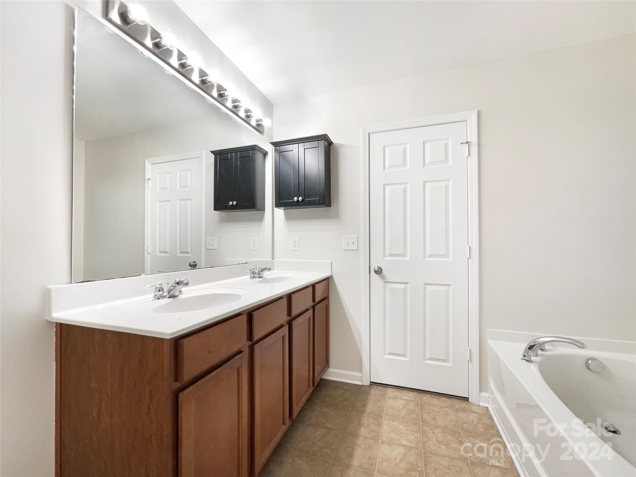 1005 Garden Web Road Indian Trail, NC 28079 - Photo 22 of 25 a spacious bathroom with a sink a large mirror and bathtub