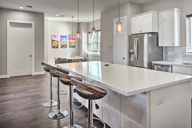 a kitchen with stainless steel appliances kitchen island a refrigerator and microwave