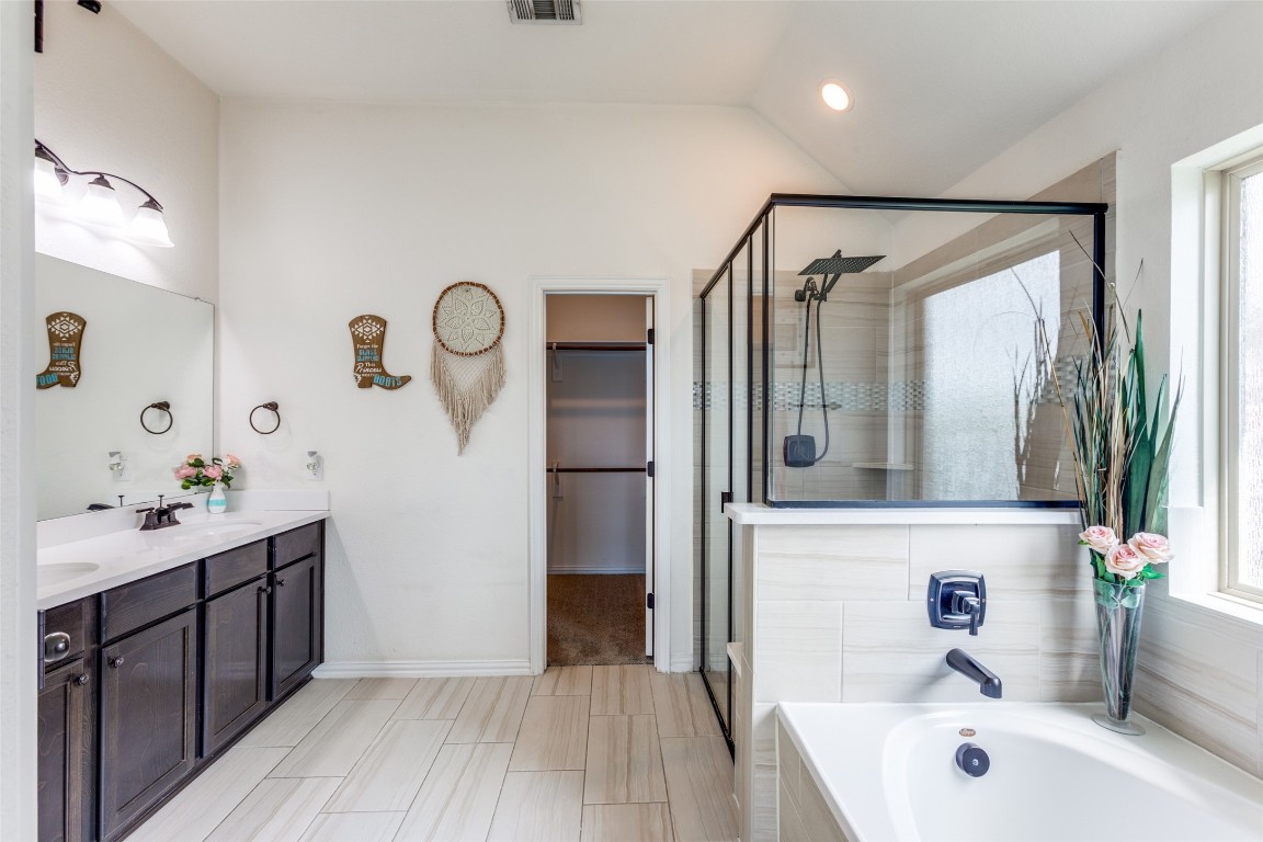 874 Spinnaker Loop Kyle, TX 78640 - Photo 15 of 30 Full bathroom with a garden tub, double vanity, a shower stall, and healthy amount of natural light