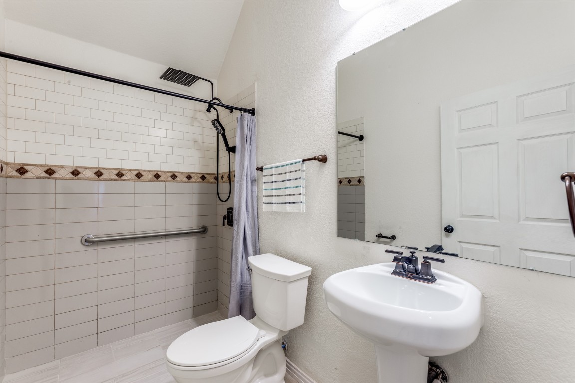 874 Spinnaker Loop Kyle, TX 78640 - Photo 16 of 30 Bathroom with a textured wall, a stall shower, and vaulted ceiling