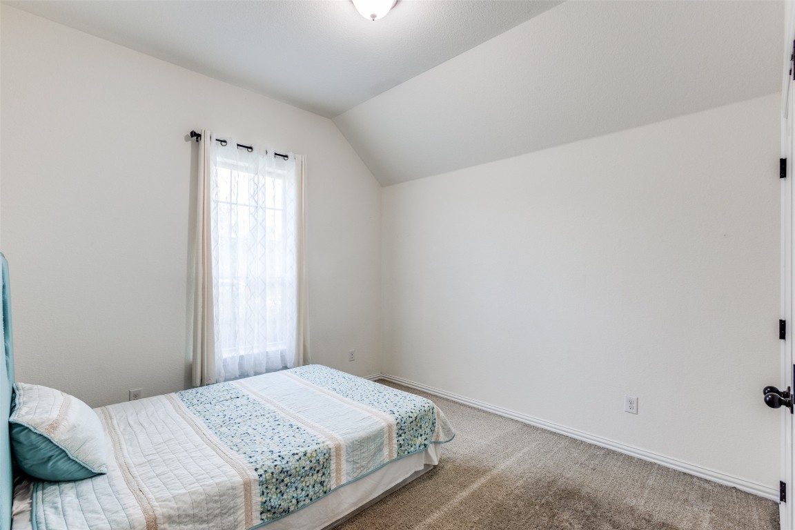 874 Spinnaker Loop Kyle, TX 78640 - Photo 18 of 30 Carpeted bedroom featuring lofted ceiling and baseboards
