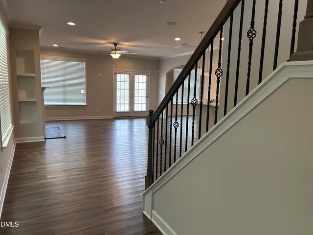 a view of a hallway with wooden floor and staircase