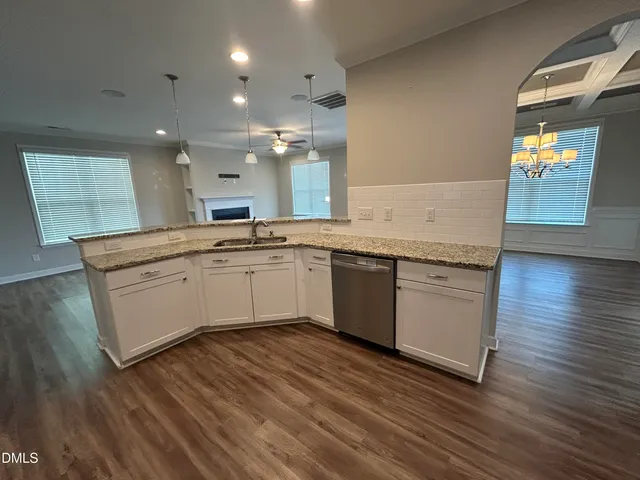 a kitchen with a sink cabinets and wooden floor