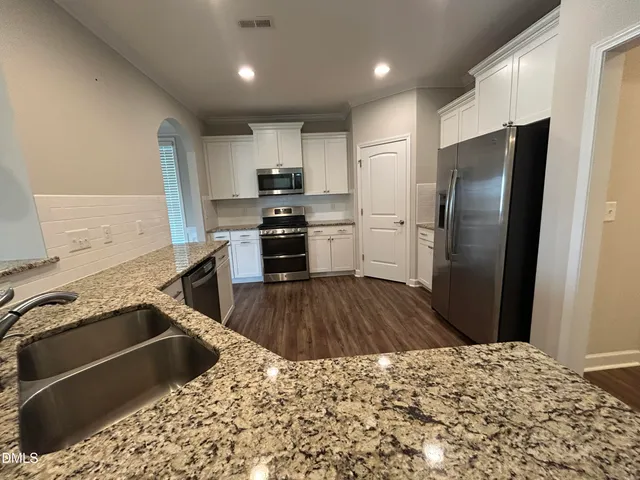 a kitchen with a refrigerator sink and wooden cabinets