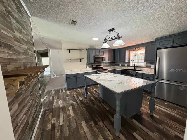 a kitchen with a sink a counter top space stainless steel appliances and cabinets