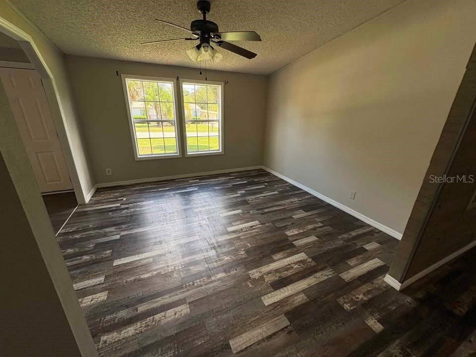 17200 Southeast 97th Terrace Summerfield, FL 34491 - Photo 7 of 14 a view of empty room with wooden floor and fan