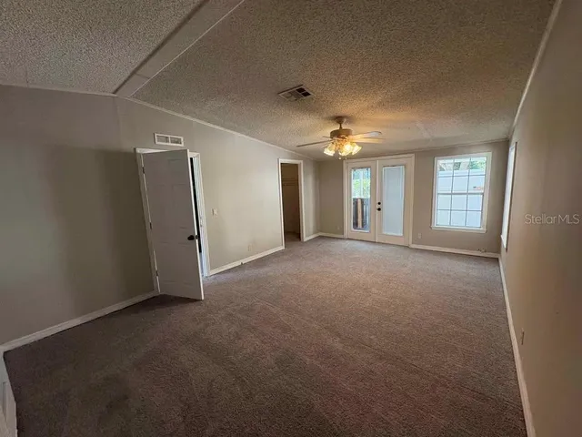 en empty room with windows and chandelier