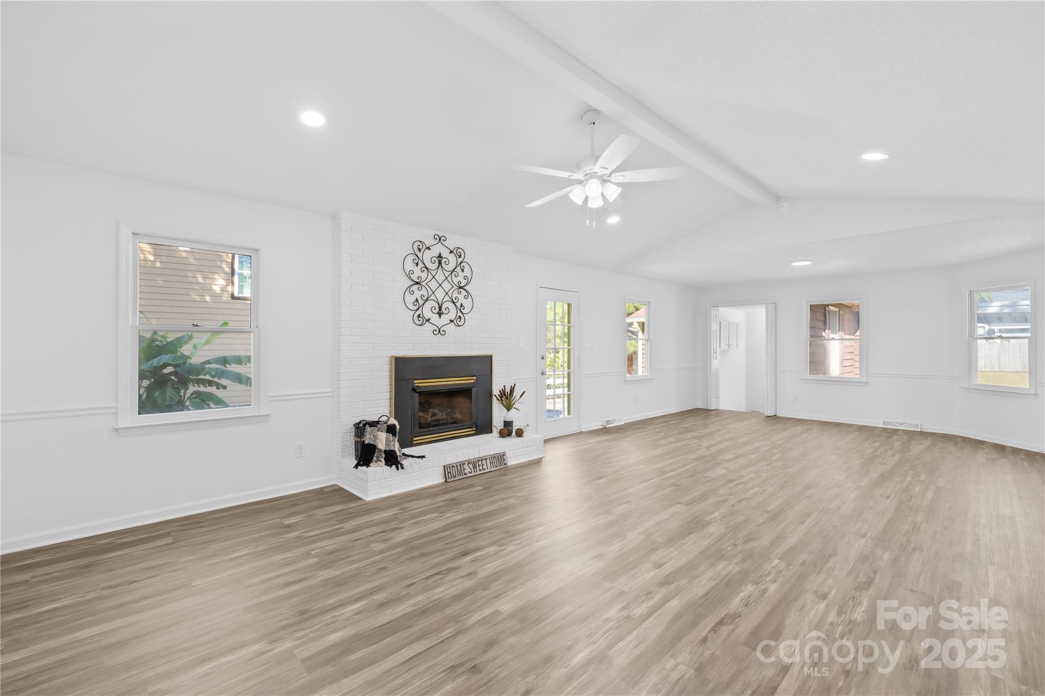 700 Chestnut Lane Matthews, NC 28104 - Photo 13 of 39 an empty room with windows a fireplace and wooden floor