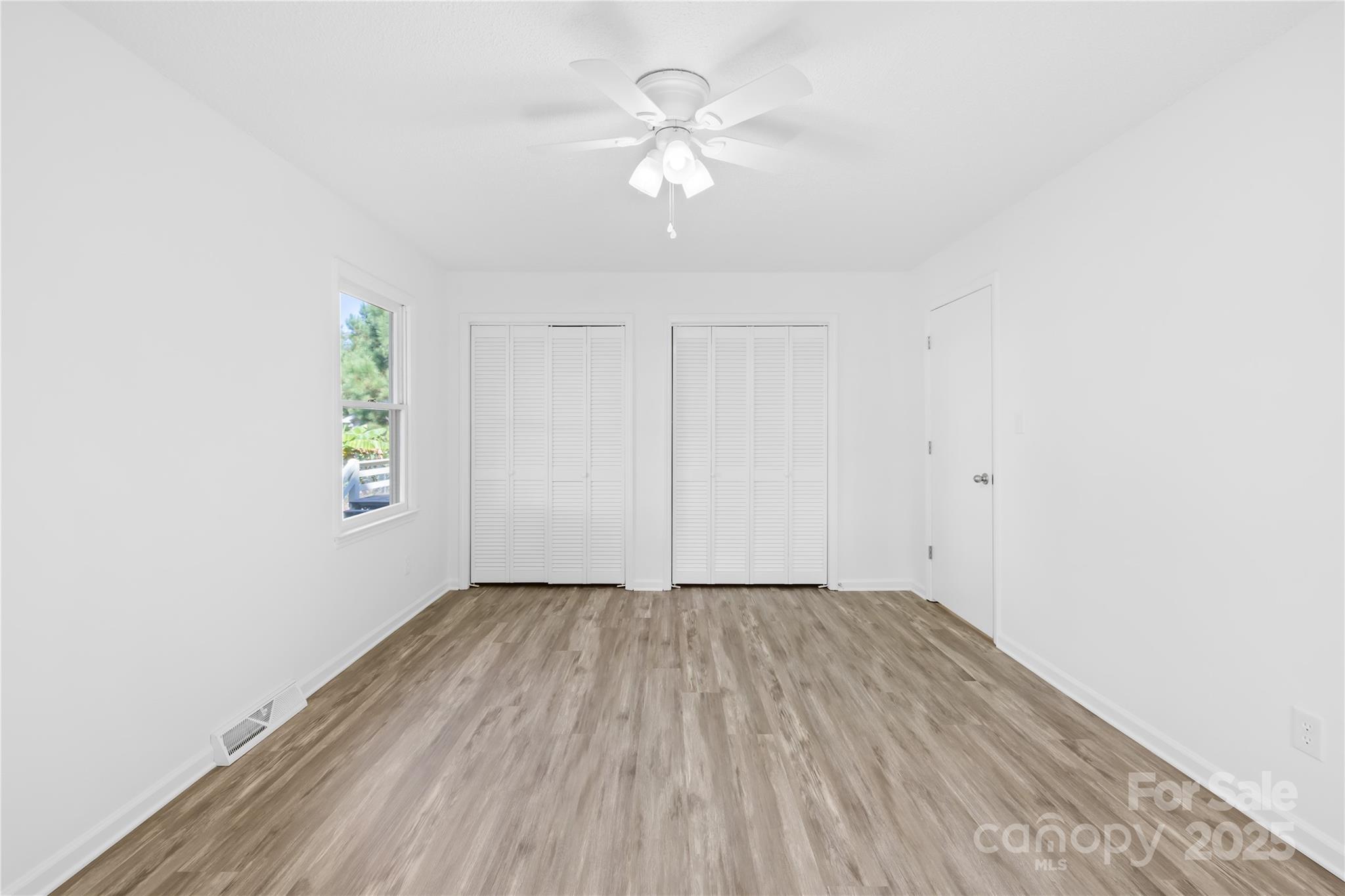 700 Chestnut Lane Matthews, NC 28104 - Photo 21 of 39 an empty room with a window and a ceiling fan