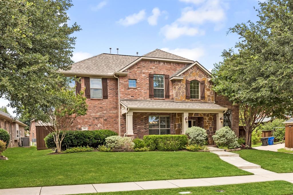 960 Remuda Road Frisco, TX 75033 - Photo 37 of 39 Two-story brick and stone exterior featuring a covered front porch with columns, a gabled roof, and dark shutters