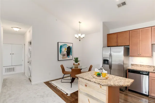 a kitchen with stainless steel appliances granite countertop a sink a stove a refrigerator and a refrigerator