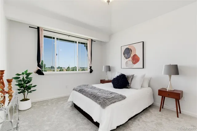 a bedroom with a bed and a potted plant