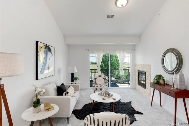a living room with furniture a large window and a dining table
