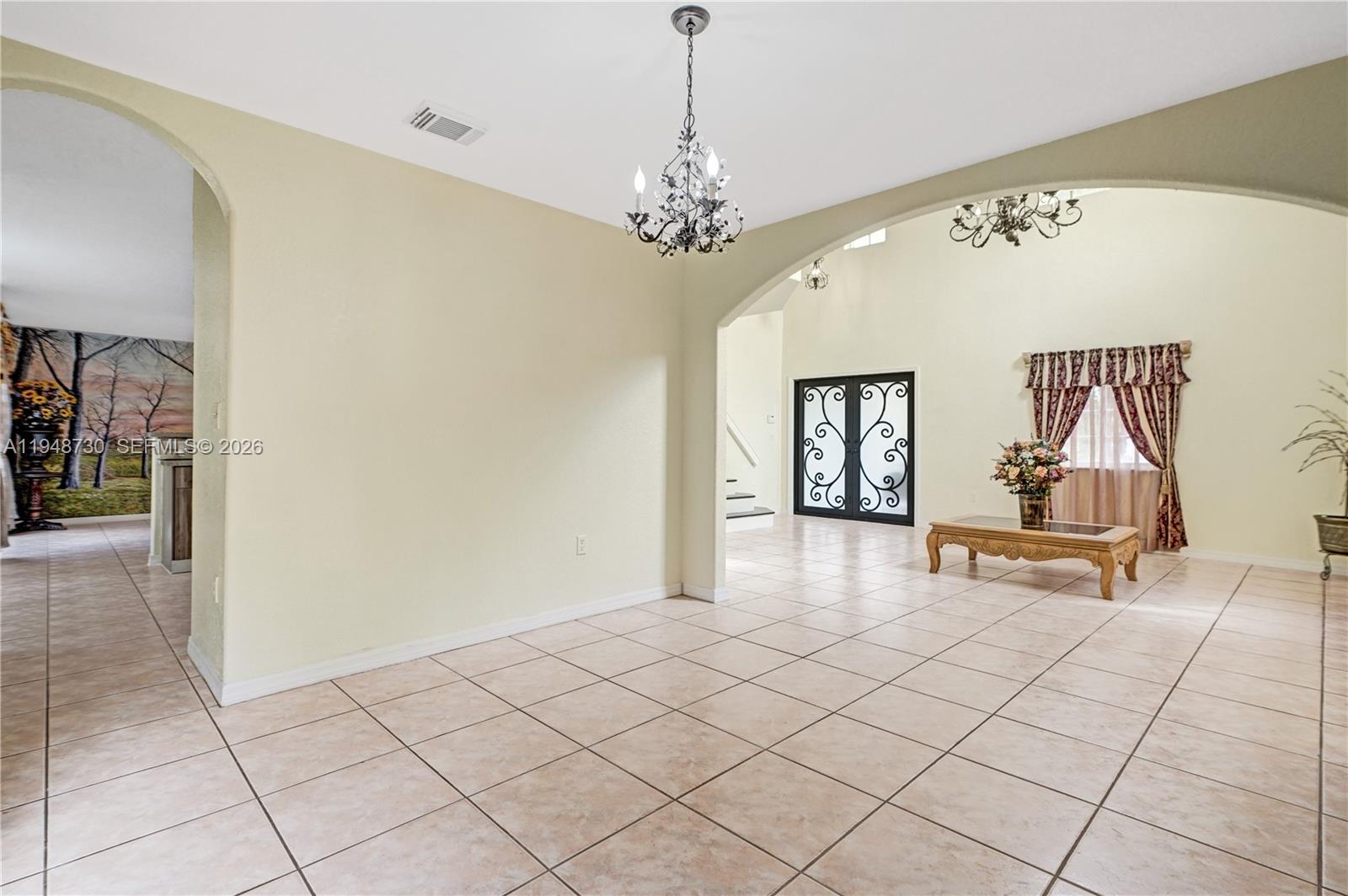 5502 Southwest 162nd Place Miami, FL 33185 - Photo 16 of 72 a view of a livingroom with a chandelier and glass door