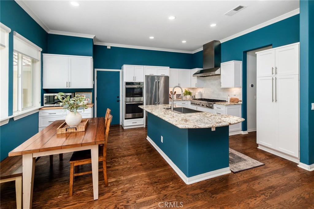 789 Glenhart Place Fallbrook, CA 92028 - Photo 11 of 40 a kitchen with kitchen island a stove a refrigerator and a dining table with wooden floor