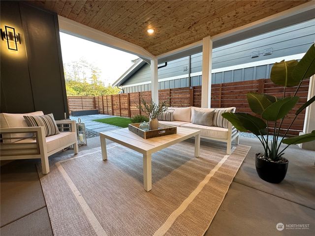 a living room with patio furniture and a potted plant