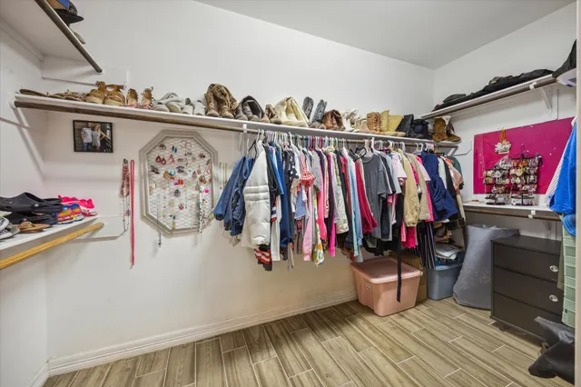 a view of walk in closet with clothes and shoes