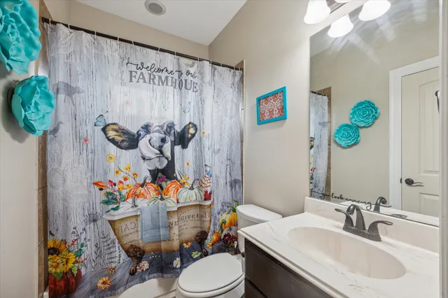 a bathroom with a sink mirror vanity and toilet
