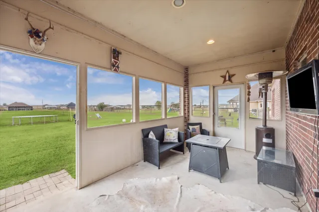 a living room with patio furniture and a floor to ceiling window