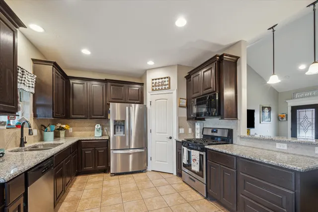 a kitchen with granite countertop stainless steel appliances and wooden cabinets