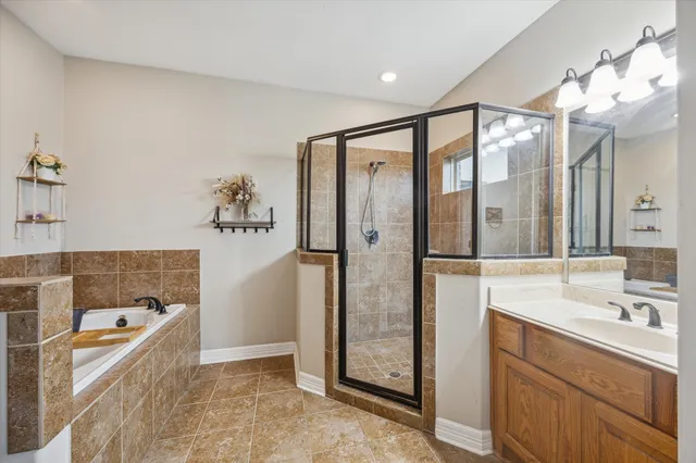 a bathroom with a granite countertop tub sink shower and mirror