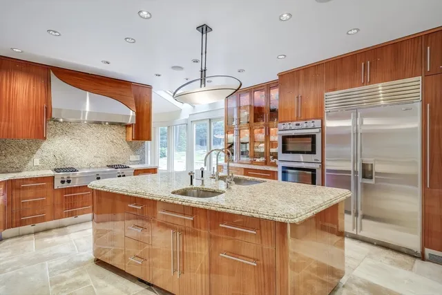 a kitchen with stainless steel appliances granite countertop a sink a stove and a refrigerator
