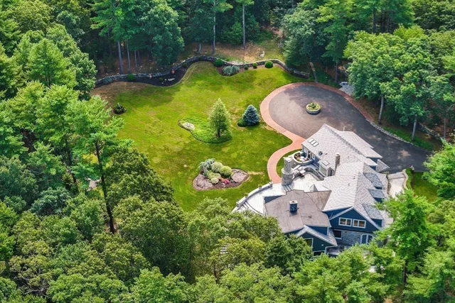 an aerial view of a house with backyard space and swimming pool
