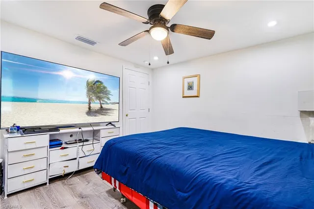 a bedroom with a bed and a ceiling fan