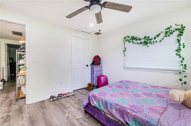 a bedroom with a bed and a chandelier fan