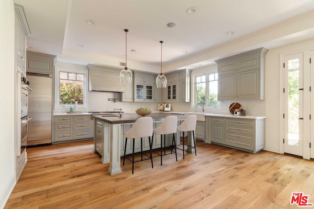 685 San Lorenzo Street Santa Monica, CA 90402 - Photo 9 of 44 a room with stainless steel appliances kitchen island granite countertop a stove a sink dishwasher and a dining table with wooden floor