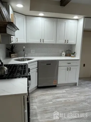 a kitchen with a sink a stove and cabinets