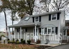 a front view of a house with a tree