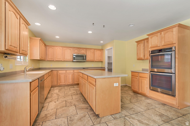 546 Wheatridge Road Tooele, UT 84074 - Photo 13 of 49 Kitchen featuring Corian countertops central island, stainless steel appliances including a double oven and built-in microwave, and tile flooring
