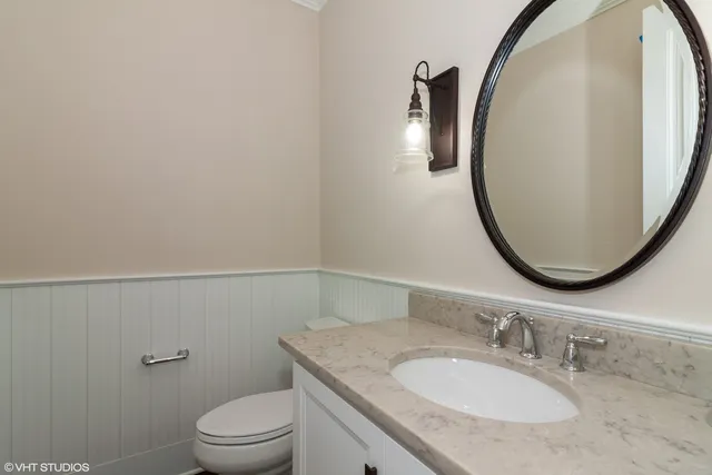 a bathroom with a granite countertop sink a toilet and a mirror