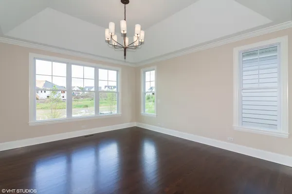 a view of a room with wooden floors and chandelier