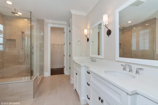 a bathroom with a double vanity sink mirror and shower