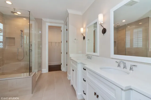 a bathroom with a double vanity sink mirror and shower