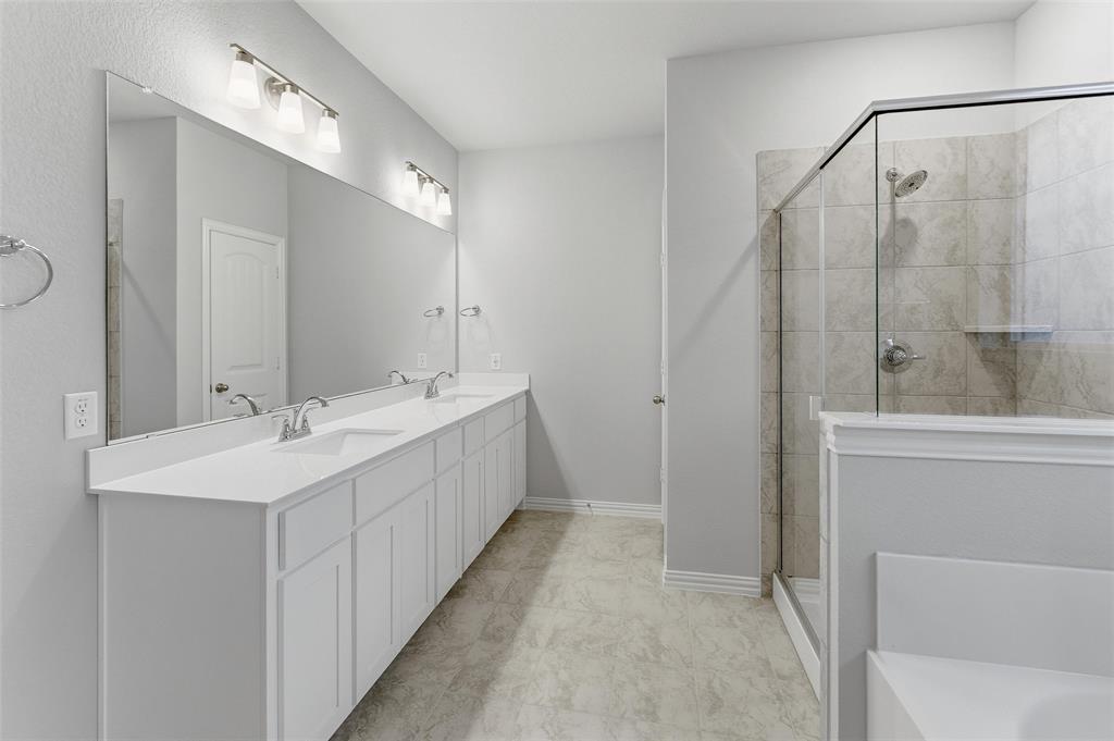 1329 Frio Drive Springtown, TX 76082 - Photo 17 of 25 Spacious bathroom featuring a dual vanity with white cabinetry and countertops, a large frameless mirror, and overhead vanity lighting