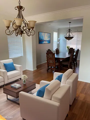 a living room with furniture a dining table and a chandelier