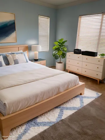 a bedroom with a bed lamp and a potted plant