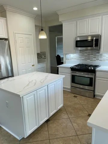 a kitchen with stainless steel appliances a stove a sink a microwave and cabinets