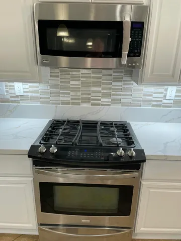 a stove top oven sitting inside of a kitchen