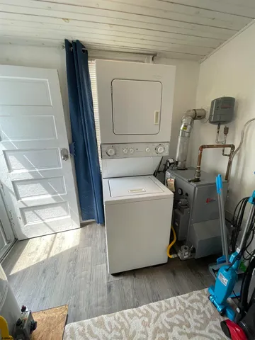 a room with water heater and wooden cabinets