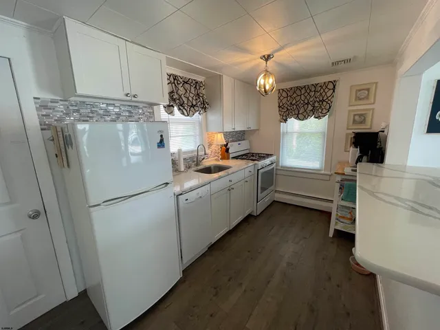 a kitchen with a refrigerator a stove and a sink